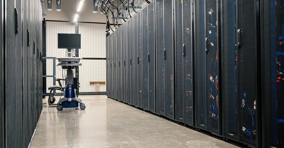 Pasillo moderno de centro de datos con estantes de servidores y equipos informáticos. Ideal para conceptos de tecnología e informática.