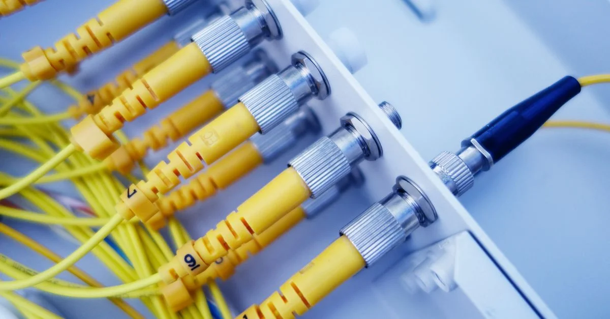 Primer plano de cables de fibra óptica amarillos en un servidor de red, que muestra la rápida transferencia de datos.