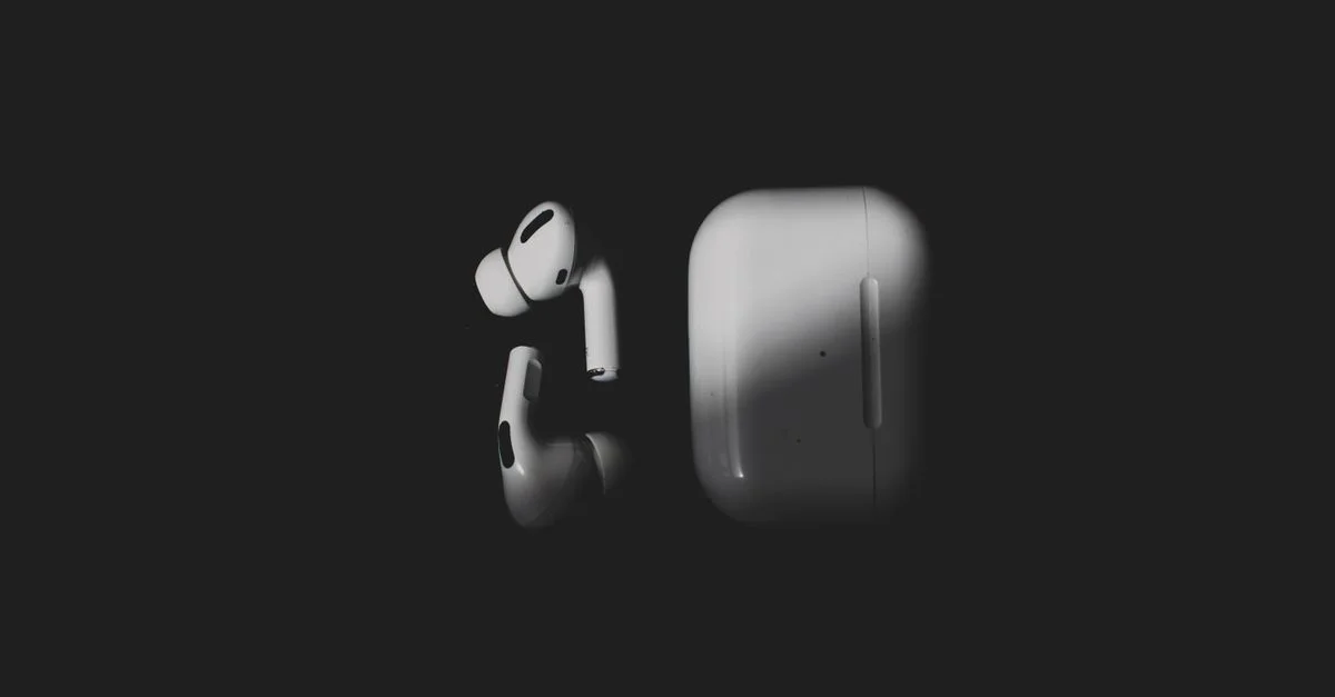 Auriculares inalámbricos elegantes y estuche de carga sobre un fondo negro elegante, con un diseño tecnológico moderno.
