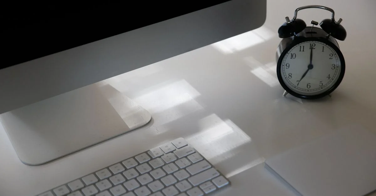 Aumenta la productividad con un espacio de trabajo elegante que cuenta con un ordenador, teclado y reloj analógico.