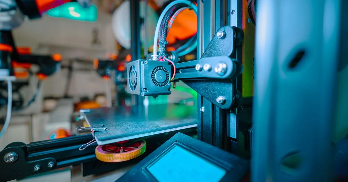 Image détaillée d'une imprimante 3D dans un environnement d'atelier industriel.