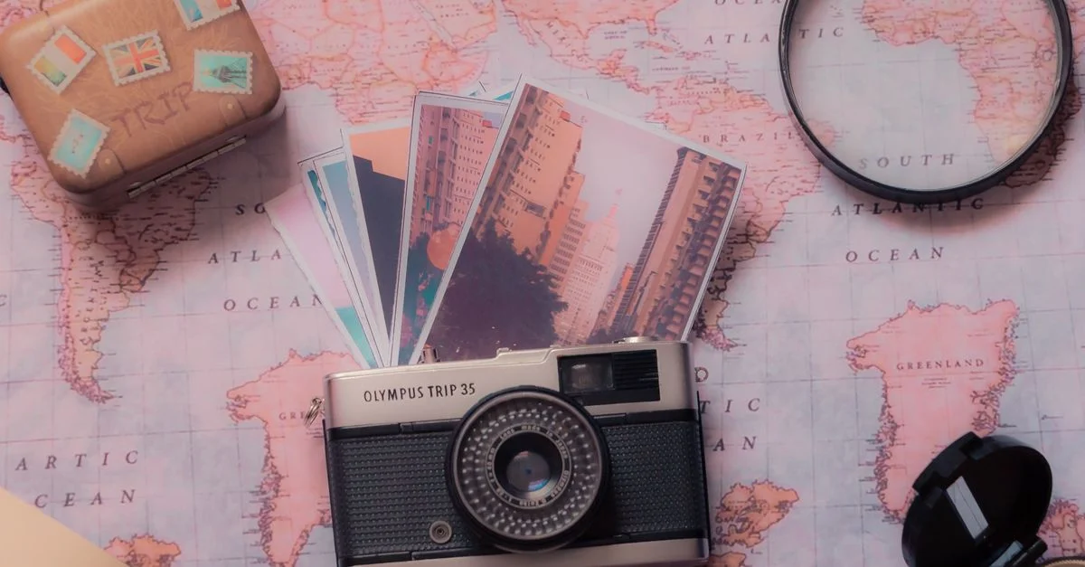 Explora la fotografía vintage con una cámara clásica y un montaje de viaje sobre un mapa mundial.