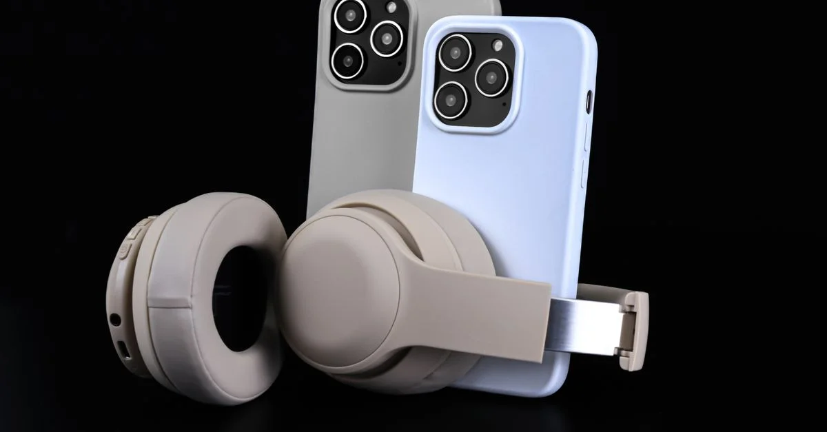 Par de smartphones con auriculares beige sobre fondo negro, mostrando tecnología moderna.