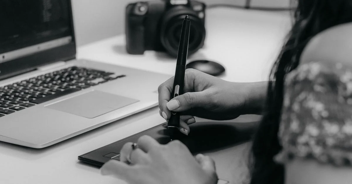 Una diseñadora trabajando con una tableta de dibujo y laptop, enfatizando la creatividad digital moderna.