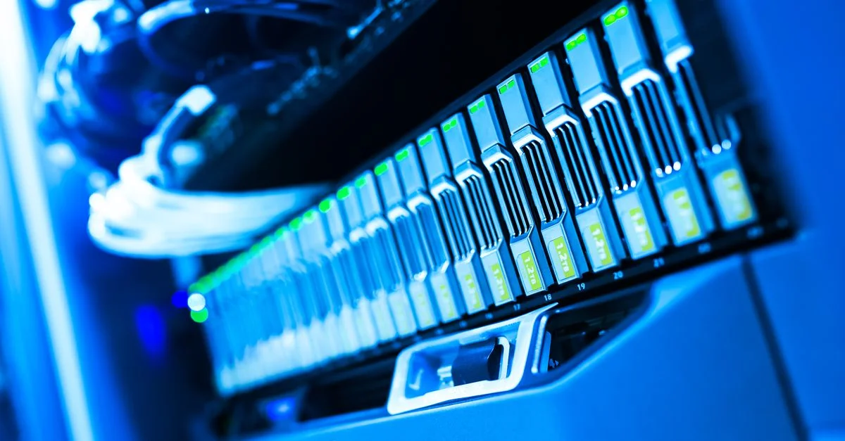 Una vista detallada de un rack de servidores iluminado en azul en un centro de datos que muestra tecnología y hardware.